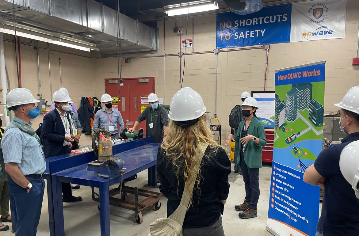 Visitors at an Enwave facility beside a deep lake water cooling display.