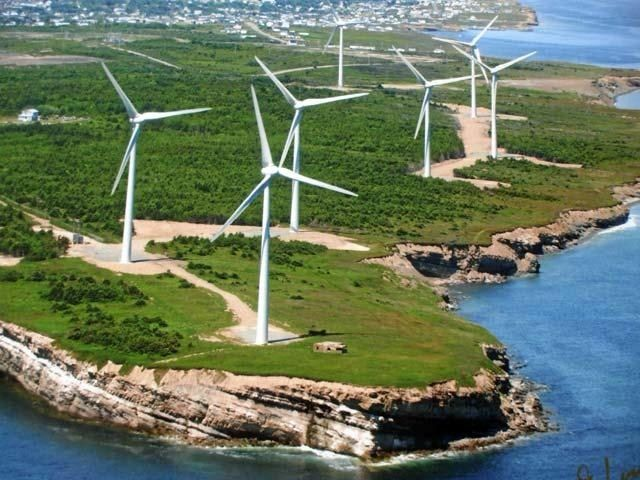 Wind turbines on a coastal headland near a community.