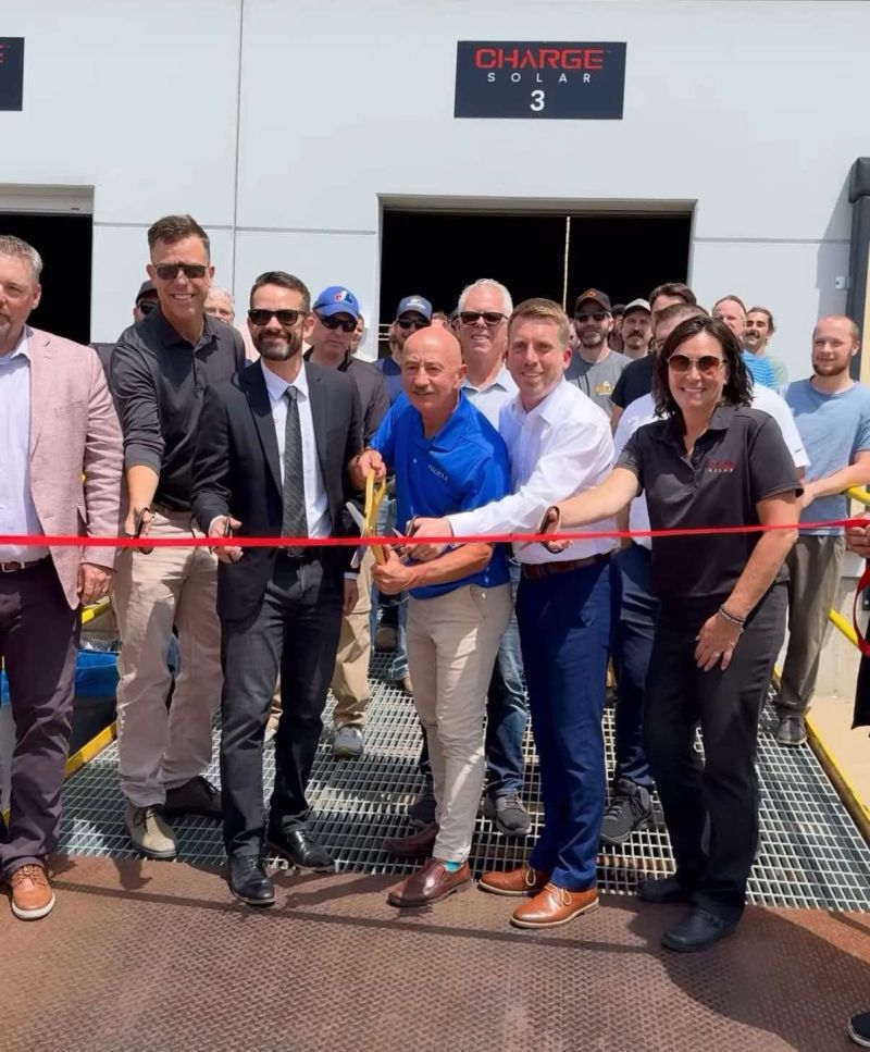 Ribbon cutting outside a Charge Solar facility.
