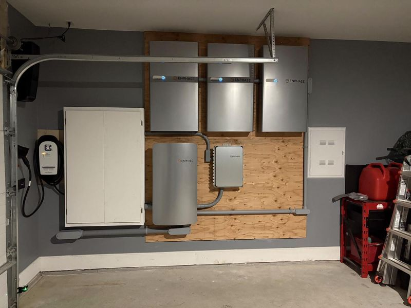 Wall-mounted Enphase home batteries and electrical equipment in a residential garage.