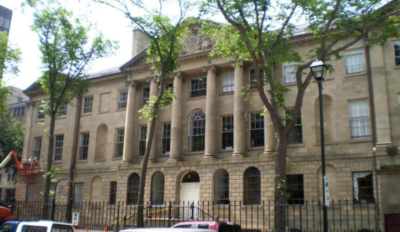 Province House in Halifax, with its stone facade and columns framed by trees.