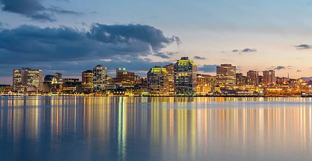Halifax waterfront skyline at dusk, with building lights reflected across the harbour.