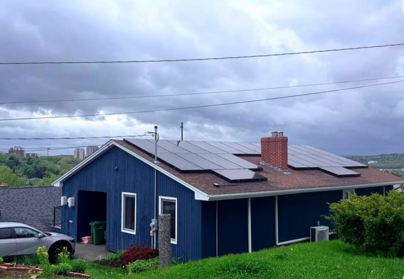 Solar panels on the roof of a blue house.